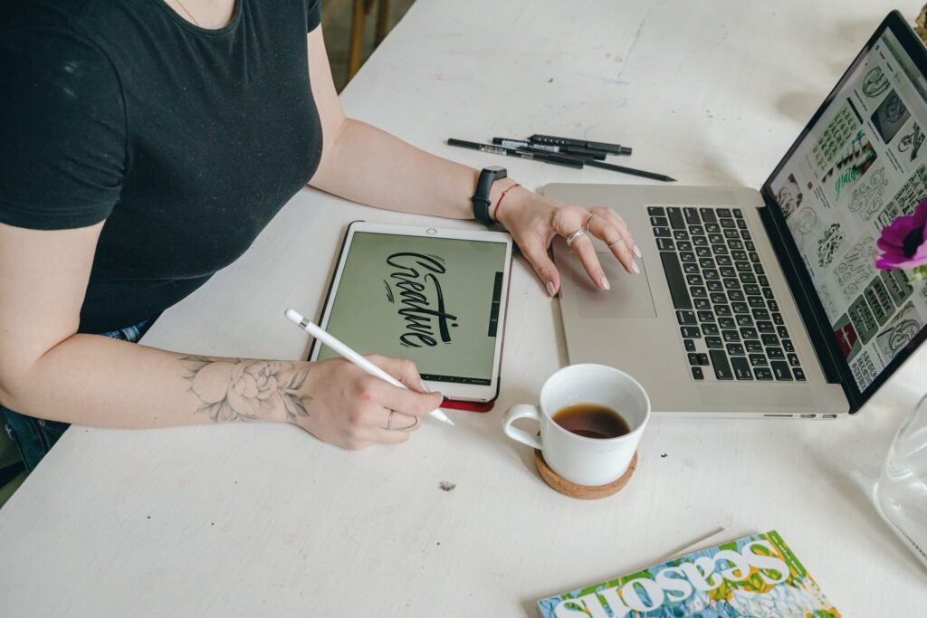 Writer drafting copy at a laptop with a tablet