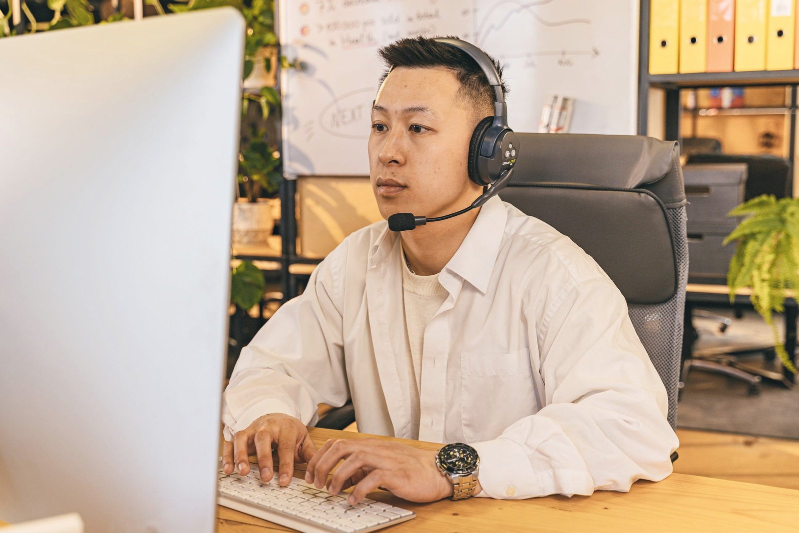 Subtitler with headset working at a large screen
